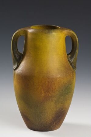  An elegant ceramic vase featuring a mustard yellow to olive green gradient, with two small handles on the sides, against a neutral gray background. The vase exhibits a classic, symmetrical shape with a smooth surface that conveys a sense of antiquity.