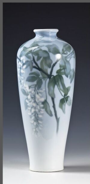  A tall, slender vase with a glossy surface featuring a monochromatic blue and gray painted botanical design, against a soft gray to white gradient background. Artist name and title remain unknown.