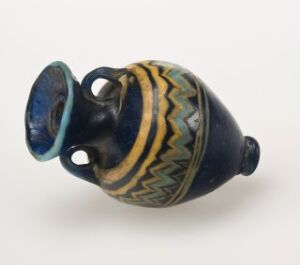  An ancient ceramic vessel with a bulbous body and a narrow round base, featuring two looped handles near the blue-glazed rim, and a decorative band with yellow and ochre chevrons around its middle.