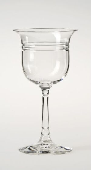  An empty, clear glass goblet with a tulip-shaped bowl, a slender stem, and a broad base, set against a light gray background.