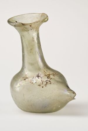  An antique, pale green glass vessel with a tulip-like shape and a silvery patch on its bulbous body, displayed against a white background. Artist name and title unknown.