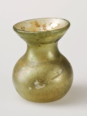  An image of an old, small vase with a bulbous bottom and a flared top, featuring a mottled pattern with olive green and brown colors, and patches suggesting historical age.