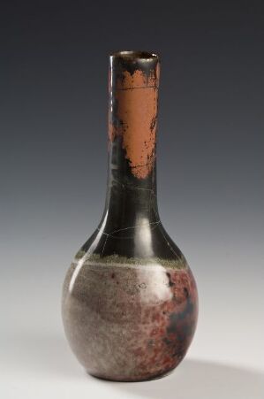  A slender-necked ceramic vase with a glossy finish, featuring a dark to medium brown gradient on the neck and speckled reddish-brown transitioning to patchy light gray at the base, against a light gray background.