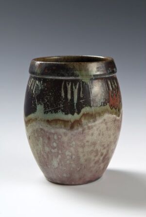  Ceramic vase with a metallic rim, a glossy black upper section with dripping streaks, a mottled gray and pink central band, and a lighter textured lower section, set against a neutral background. Artist name and title are unknown.