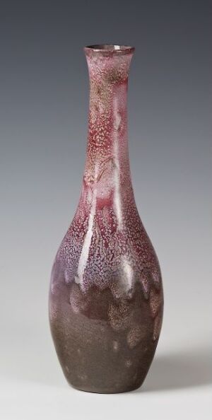  A slender, glossy vase with a narrow opening, featuring a deep burgundy to soft pink gradient and speckled with light gray, creating a frosted appearance against a subtle gray gradient background. Artist and title unknown.