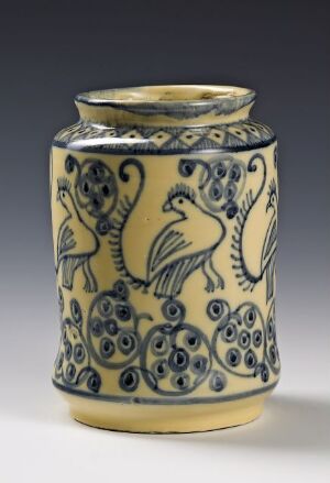  A historically styled ceramic jar with a creamy off-white background, adorned with intricate cobalt blue and mustard yellow patterns featuring stylized birds and floral elements.