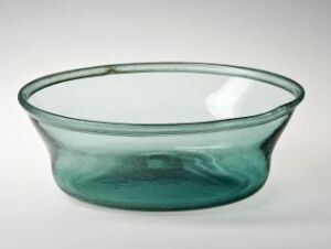  A translucent, sea-green glass bowl with a wide brim and a flat base, exhibiting subtle color variations from darker edges to a lighter center.