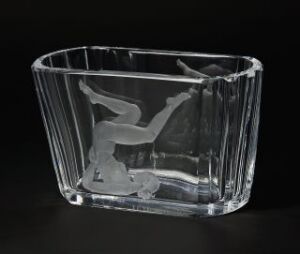  A transparent glass or crystal rectangular bowl with vertical ridges and an etched mermaid figure inside, placed against a dark background.