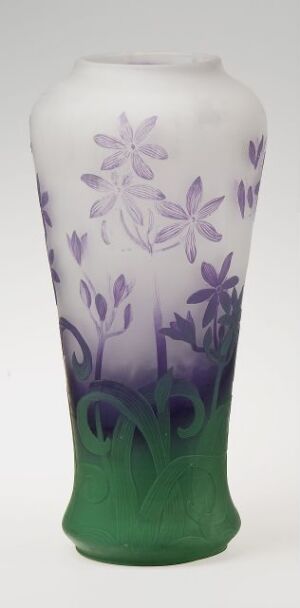  A slender glass vase that transitions from a green base to a milky white top with etched lilac floral patterns, conveying an impression of natural tranquility.