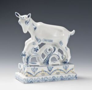  A porcelain goat figurine designed by Thorleif Sohlberg, rendered in white with blue decorative patterns and gold embellishments on a pedestal.