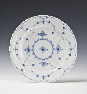  A round feldspar porcelain plate from Porsgrunds Porselænsfabrik AS featuring the 'Stråmønster' design, with hand-painted underglaze decorations in cobalt blue on a white glossy background, exhibiting intricate radial patterns and floral motifs.