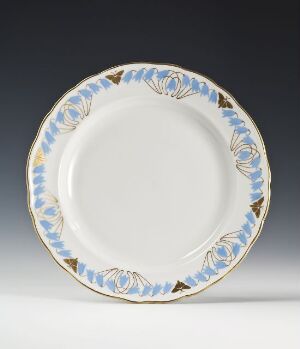  A feldspar porcelain plate titled "Blaaklokker" designed by Thorolf Holmboe, featuring a creamy white base with handpainted bluebell flowers in shades of blue and green, accented with gold detailing along the rim.