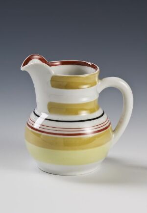  A porcelain jug from Porsgrunds Porselænsfabrik AS, with a cream base color and decorated with vibrant stripes in maroon, black, green, and yellow. The jug has a traditional shape with a wide base and an ergonomic handle.