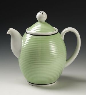  A light green, ribbed feldspar porcelain teapot with lid, created by Porsgrunds Porselænsfabrik AS, against a neutral background. It features a smooth gradient color, a gracefully curving spout, and an ergonomic handle.