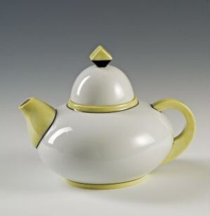  A white feldspar porcelain teapot with lemon-yellow highlights on the lid, handle, and spout, designed by Porsgrunds Porselænsfabrik AS.