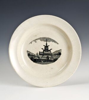  A cream-colored ceramic plate with a glossy finish, featuring a central circular monochromatic illustration of an early 20th-century warship on the sea with a dirigible floating overhead.