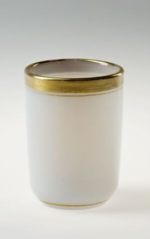  A cylindrical off-white jar with a lustrous gold lid on a light grey-to-white gradient background, exuding minimalism and practical elegance.