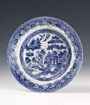  A traditional blue and white earthenware plate made by Egersunds Fayancefabrik, showcasing an Oriental-inspired landscape scene with a bridge and pavilion surrounded by ornate border designs done in underglaze blue print.