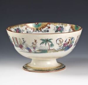  A vintage, hand-decorated bowl by Egersunds Fayancefabrik sits against a neutral background. The bowl has an intricate, hand-colored oriental scene with figures in traditional attire and elements of nature within a creamy white glaze and ornate golden-edged rim.