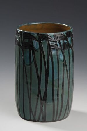  A cylindrical ceramic vase with a lustrous teal glaze and vertical streaks of varying shades, standing against a soft gray gradient background.