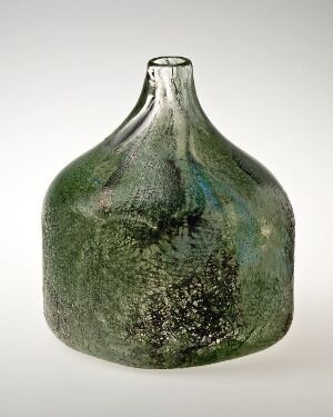  A vintage green glass bottle with a textured surface, featuring shades of deep forest green with hints of blue, brown, and white, conveying a sense of age and natural coloring.