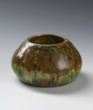  A handcrafted ceramic pot with a rounded body and a soft constriction at the opening, featuring a rich earthy green glaze with streaks of brown, against a smooth gradient gray background. Artist name and title are unknown.