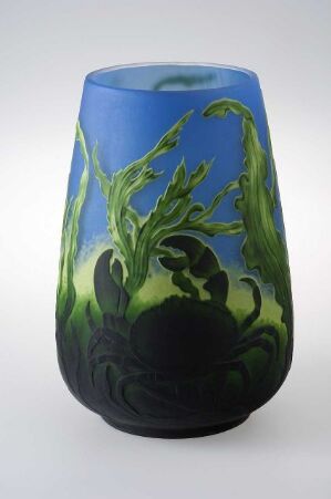  A glass vase with a gradient from opaque black at the base, through vibrant green with plant designs, to a serene blue at the top. Artist name and title unknown.