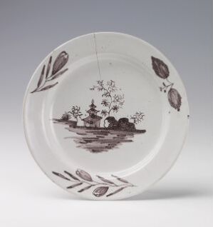  A monochromatic, pastoral scene is illustrated on a white ceramic plate with a decorative border of leaf motifs. The plate is tilted on its edge against a light-colored background, showcasing the simplicity and elegance of the black and gray design.