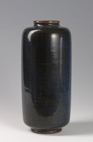  A tall, dark blue glossy stoneware vase titled "Farsta" by Gustavsberg fabriker, with a narrow brown rim at the top, set against a neutral gray background.