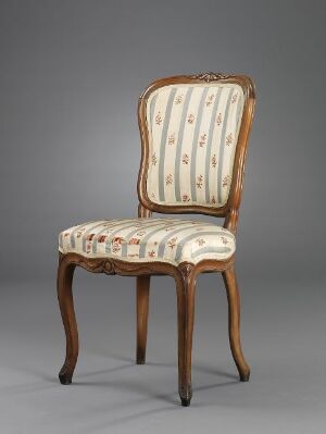  An elegant classic chair with a cream and reddish-brown floral patterned upholstery and a light brown wooden frame, set against a grey background.