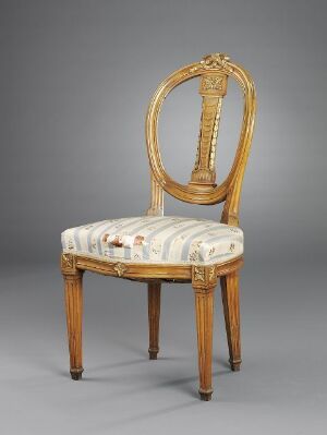  An elegantly designed antique wooden chair with a lyre-shaped backrest and light striped fabric upholstery on the seat, set against a plain grey background.