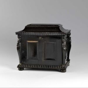  A baroque-style ebony-veneered cabinet known as "Kabinettskap" by an unidentified artist, featuring carved decorations, brass fittings, and doors suggesting a detailed interior.