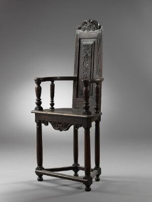  An ornate walnut chair titled "Stol" by an unidentified artist, featuring intricate carving, turned spindles and stretchers, and rich brown hues against a neutral gray background.