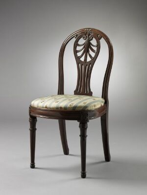  An elegant mahogany chair with a radiating pattern carved into the backrest and turned details on the front legs, featuring a light-colored upholstered seat with a striped and floral pattern.