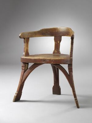  An antique wooden chair with a curved backrest and an 'X' shaped stretcher connecting the legs, displayed against a light gray gradient background. The chair has a medium to dark brown patina with visible signs of wear, especially on the seat and top rail, emphasizing its age and use.