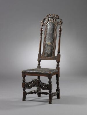  Antique, highly decorative chair with a gilded, carved high backrest, an upholstered panel, and detailed wooden legs against a gradated background.