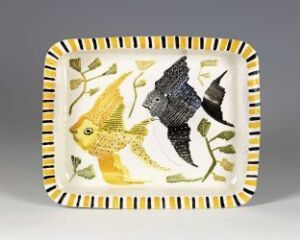  A small rectangular ceramic plate with rounded corners featuring two stylized fish, one yellow and the other dark with white accents, surrounded by green seaweed impressions. The rim is adorned with yellow and black ticking stripes. Artist name and title are unknown.