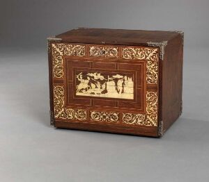  An antique wooden box with intricate cream inlays depicting a classical scene on the front panel, surrounded by a decorative scroll and leaf pattern.