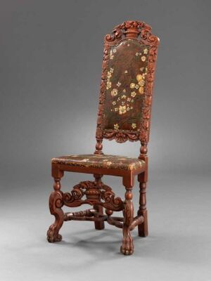  An intricately carved dark brown wooden chair with a tall, camelback-shaped upholstered backrest featuring a floral pattern in autumn colors, and turned legs connected by an H-shaped stretcher.