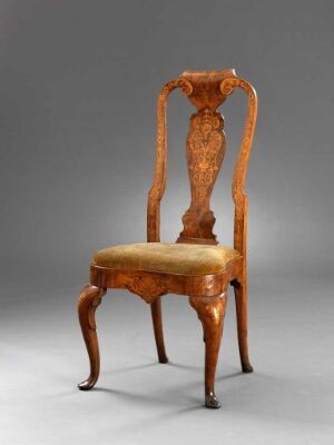  An antique wooden chair with elegant carvings and a golden brown glossy finish, featuring a padded seat in a soft beige fabric and curvaceous cabriole legs, set against a soft gray background.