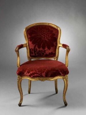  "Armstol" by Johan J. Katzenberg, a luxurious gilded birch armchair with intricate carvings and red velvet upholstery, exemplifying opulent historical furniture design.