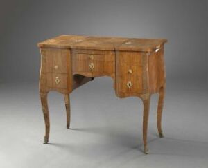  Antique wooden desk with curved legs and three drawers, each with brass fittings, on a neutral grey background.