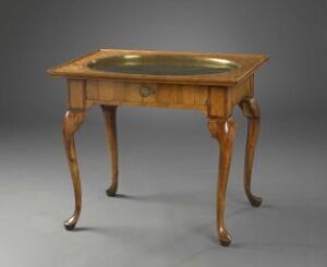  A varnished mahogany table titled "Tebord" by an unidentified artist, featuring curved edges, intricate cabriole legs with carved details, and brass inlays, set against a neutral gray background.