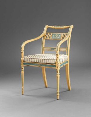  An antique beechwood armchair with rattan weaving by Joseph Chr. Lillie, titled "Møblement". The chair has a golden brown finish, detailed turning and profiling on its frame, a woven rattan back and armrests, and a striped silk cushion on the seat, set against a neutral gray background.