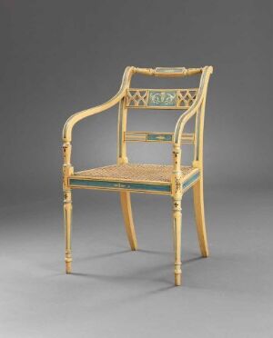  A beechwood armchair titled "Stol" by Joseph Chr. Lillie, featuring turned, carved, and painted decorations, with a woven rattan seat against a neutral grey background.