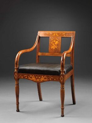  An antique wooden armchair with a deep-brown glossy finish, featuring ornate floral carvings on the backrest and arms, complemented by a cushioned seat upholstered in black fabric, against a dark gray background.