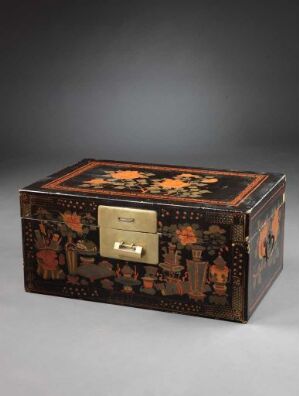  An antique decorative chest with intricate East Asian-style black, orange, red, gold, and green patterns, featuring detailed scenes with floral elements and figures, centered around a golden clasp on the front.