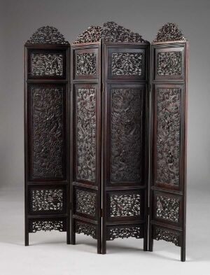  An intricately carved four-panel folding screen, each panel topped with an ornate lattice pattern above a densely carved lower section depicting intertwined floral designs, in a uniform dark brown color.