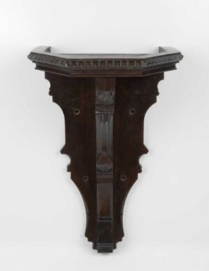  A dark wooden, wall-mounted console table with intricate carvings against a light background. The table has a semi-circular top and an elongated, tapered body, styled in a traditional design.