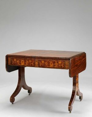  An antique wooden table with a rectangular top, inlaid decorative apron, and curved legs on casters, set against a blank background. The table exhibits a rich reddish-brown color with intricate details indicative of traditional craftsmanship.